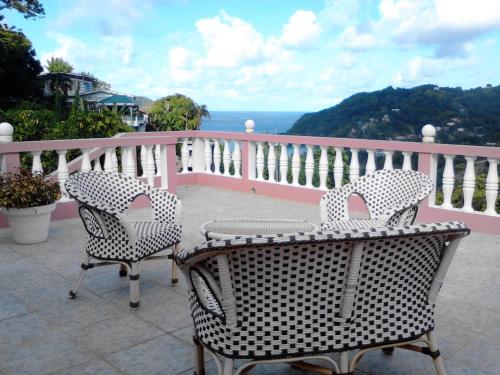 two chairs and a table on a balcony at Top Ranking Hill View Guesthouse in Speyside