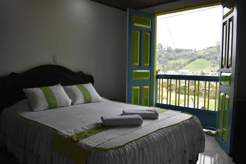 a bedroom with a bed with a large window at Posada Dónde Cupeto in Salento
