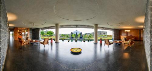 a room with a table and chairs and a large window at Viveda Wellness Resort in Nashik