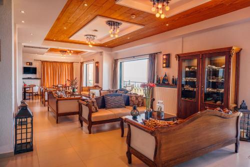 a living room with couches and a dining room at Natura Club Hotel & Spa - Adults Guests in Kyparissia