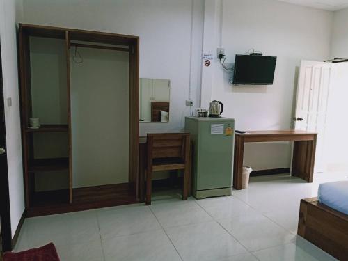 a living room with a green refrigerator and a table at Rachawadee House in Phangnga