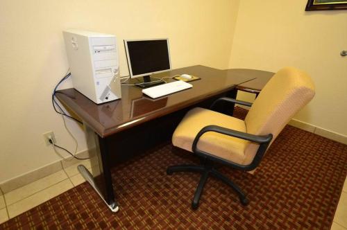 a desk with a computer monitor and a chair at Best Western Casa Villa Suites in Harlingen