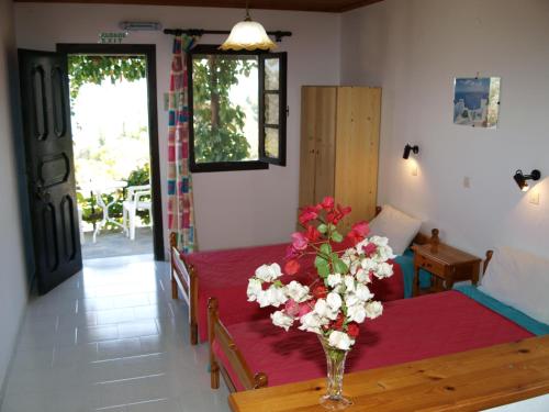 a room with two beds and a vase of flowers at Gregory Studios in Kokkari
