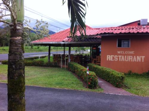 a building with a sign that reads welcome to a restaurant at Hotel Villas Vista Arenal in Fortuna