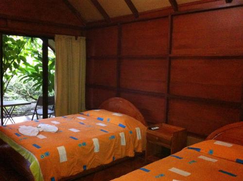 a room with two beds and a window at Hotel Villas Vista Arenal in Fortuna