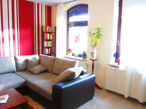 a living room with a couch and a window at Hansis Lodge in Klingenthal