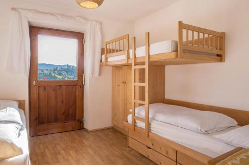 1 Schlafzimmer mit 2 Etagenbetten und einem Fenster in der Unterkunft App Schlern - Gasser in Vols am Schlern