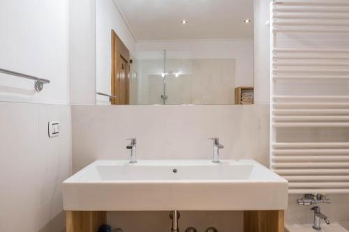 a bathroom with a white sink and a mirror at App Schlern - Gasser in Vols am Schlern