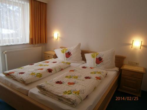 a bedroom with two beds with white comforters at Alpenview Lechtal in Holzgau