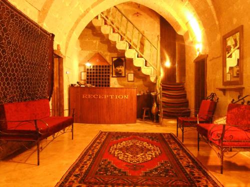 a living room with chairs and a rug on the floor at Kapadokya Ihlara Konakları Otel Konak Odaları in Guzelyurt