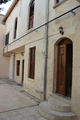 an old building with a wooden door and a street at Duran Aga Konagi in Şahinbey