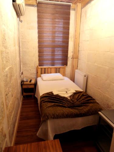 a small room with a bed and a window at Duran Aga Konagi in Şahinbey