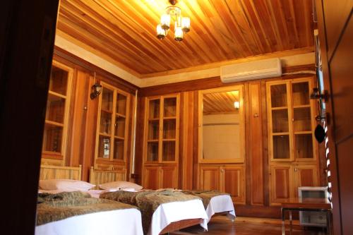 Duran Aga Konagi في Şahinbey: غرفة نوم بأربعة أسرة في غرفة بجدران خشبية