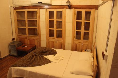 a small room with a bed and some windows at Duran Aga Konagi in Şahinbey