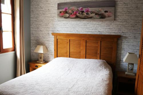 a bedroom with a white bed and a brick wall at Auberge de la Vieille Ferme in Le Meux