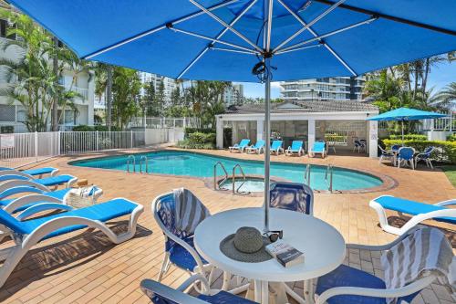 a patio with chairs and a table with an umbrella at Chidori Court in Gold Coast