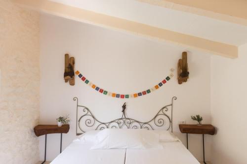 a white bedroom with a white bed with flags on the wall at Can Estaràs in Fornalutx