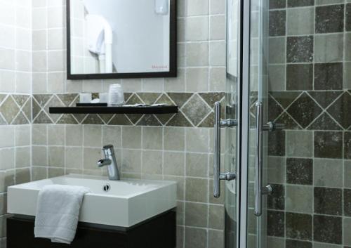 a bathroom with a sink and a shower at Auberge de la Vieille Ferme in Le Meux