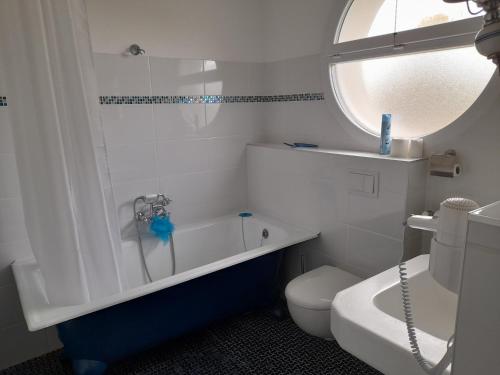 a bathroom with a tub and a toilet and a sink at Maison Art Deco-5 suites, piscine, clim, parking in Labouheyre