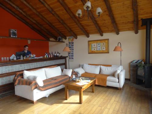 a living room with two couches and a bar at Infinito Sur in El Chalten