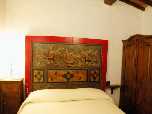 a bedroom with a bed and a wooden cabinet at Agriturismo Istrice Innamorato in Campello sul Clitunno
