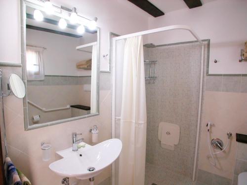 a bathroom with a sink and a shower with a mirror at Agriturismo Istrice Innamorato in Campello sul Clitunno