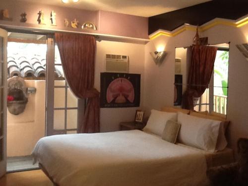 a bedroom with a large white bed and a window at Les Artistes Inn in San Diego