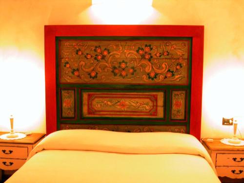 a bed with a red headboard in a bedroom at Agriturismo Istrice Innamorato in Campello sul Clitunno
