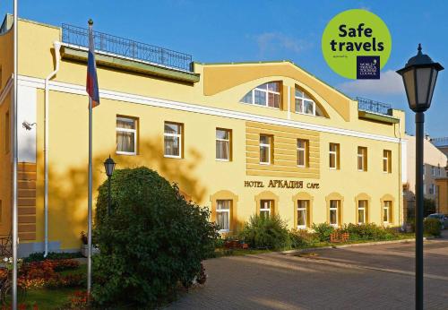 a yellow building with a sign that reads safe travels at Arkadia Hotel in Saint Petersburg