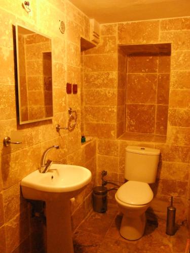 a bathroom with a toilet and a sink at Kapadokya Ihlara Konaklari & Caves in Guzelyurt