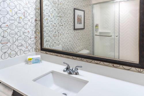 a bathroom with a sink and a mirror at Holiday Inn Milwaukee Airport by IHG in Milwaukee