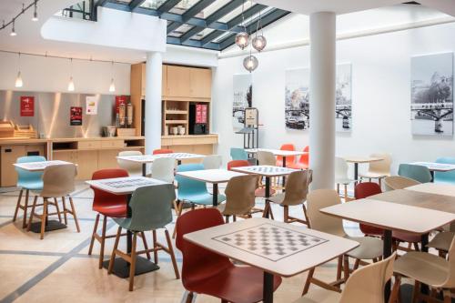 a restaurant with tables and chairs in a cafeteria at ibis Paris Opera La Fayette in Paris