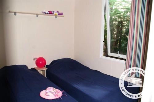 a bedroom with two beds with blue sheets and a window at Camping Montana Parc - Gassin Golfe de St Tropez - Maeva in Gassin