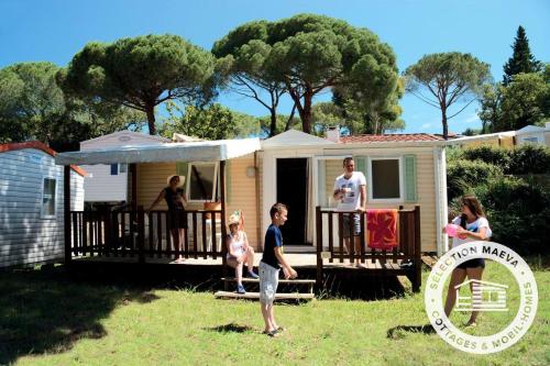 a family standing outside of a tiny house at Camping Montana Parc - Gassin Golfe de St Tropez - Maeva in Gassin
