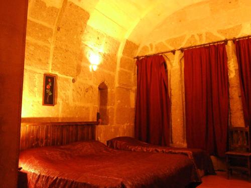 a bedroom with two beds in a stone building at Kapadokya Ihlara Konaklari & Caves in Guzelyurt