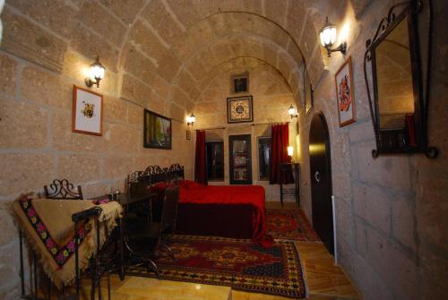 a room with a red bed in a stone building at Karamanli Konagi in Guzelyurt
