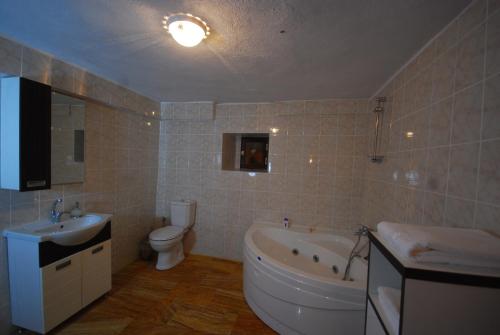 a bathroom with a tub and a toilet and a sink at Karamanli Konagi in Guzelyurt