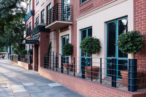 a brick building with windows and potted plants on a sidewalk at Majestic Tynte Street Apartments in Adelaide