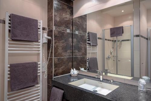 a bathroom with a sink and a shower at Alte Landratsvilla Hotel Bender in Westerburg