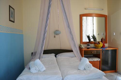 1 dormitorio con 1 cama con 2 almohadas blancas en Hotel Europe Inn, en Paralia Katerinis