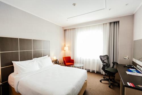 une chambre d'hôtel avec un grand lit et un bureau dans l'établissement Four Elements Perm, à Perm
