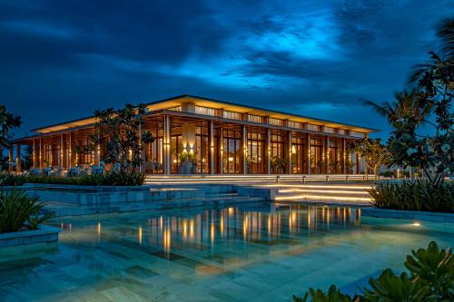 a building with a pool in front of it at night at Maia Resort Quy Nhon in Quy Nhon