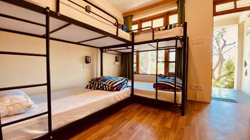 a room with two bunk beds and a window at Madpackers Manali in Manāli