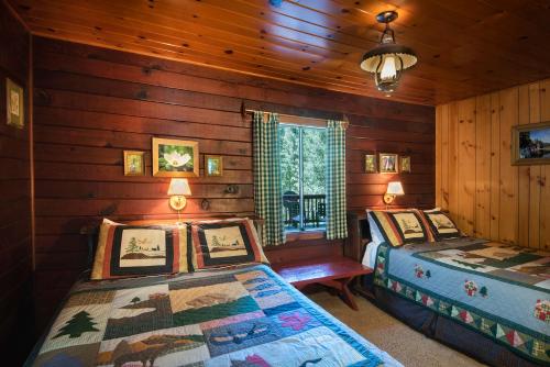 1 dormitorio con 2 camas en una cabaña de madera en 3N Lockwood Lodge, en Wawona