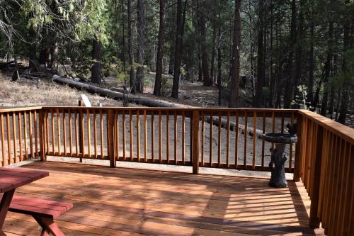 a wooden deck with a bird feeder and a picnic table at 11B Sequoia House in Wawona