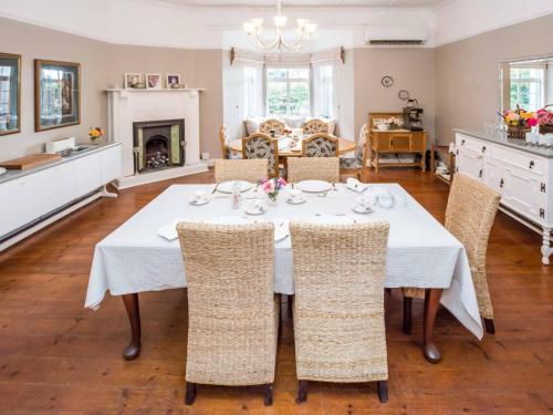una sala da pranzo con tavolo e sedie bianchi di Chicane Bed and Breakfast a Sunland