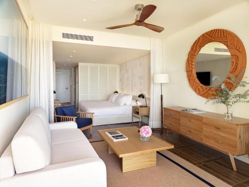 a living room with a white couch and a bed at H10 Imperial Tarraco 4 Sup in Tarragona