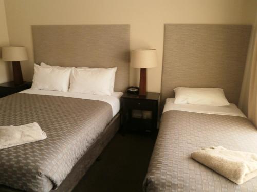 a hotel room with two beds and two lamps at Ballarat Central City Motor Inn in Ballarat