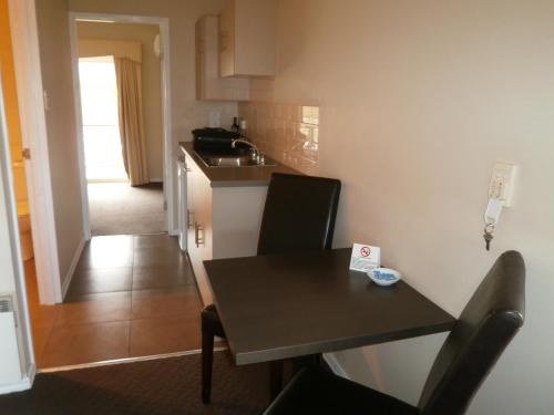 a small kitchen with a table and a sink at Ballarat Central City Motor Inn in Ballarat