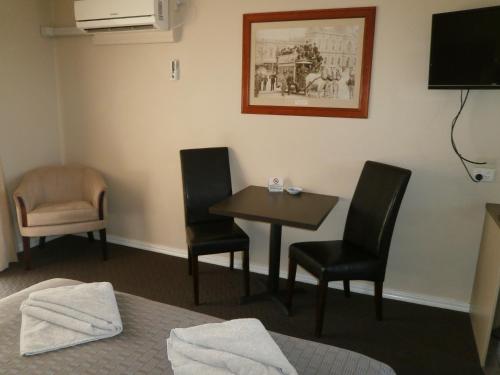 a hotel room with a table and two chairs at Ballarat Central City Motor Inn in Ballarat